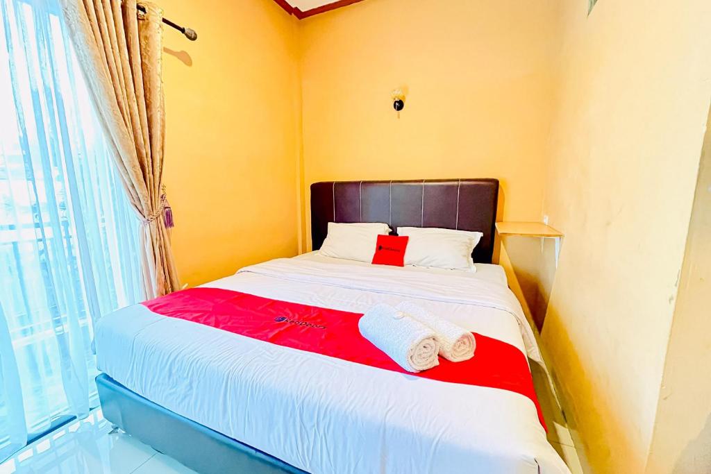 a bedroom with a bed with two towels on it at RedDoorz at Hotel Dieng Berastagi in Berastagi