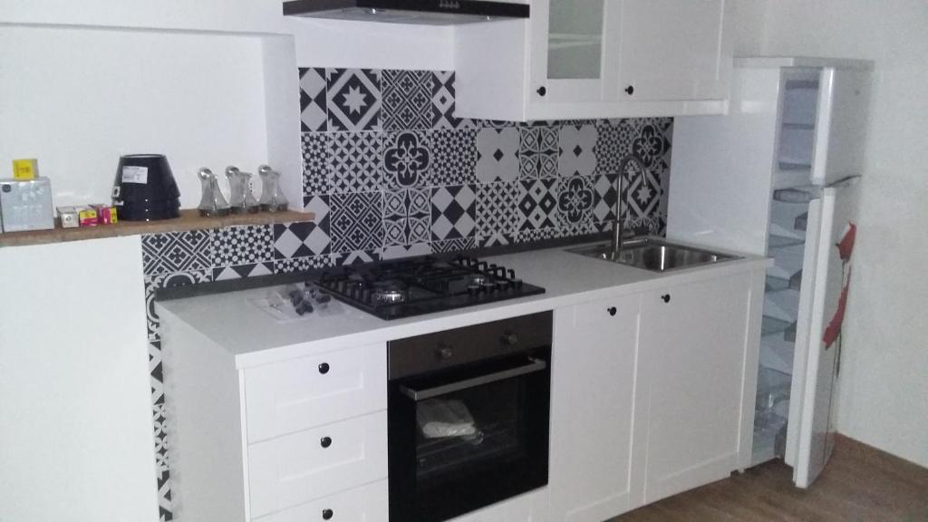 a white kitchen with a stove and a sink at Appartamento Clementini in Orvieto