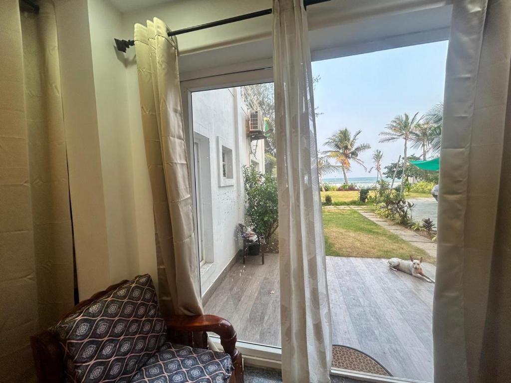 a room with a window with a view of a patio at Waves - for Family & Married Couples only in Mahabalipuram