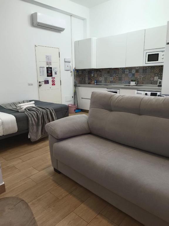 a living room with a couch and a bed at RockSide Residences Suites La Línea VII in La Línea de la Concepción