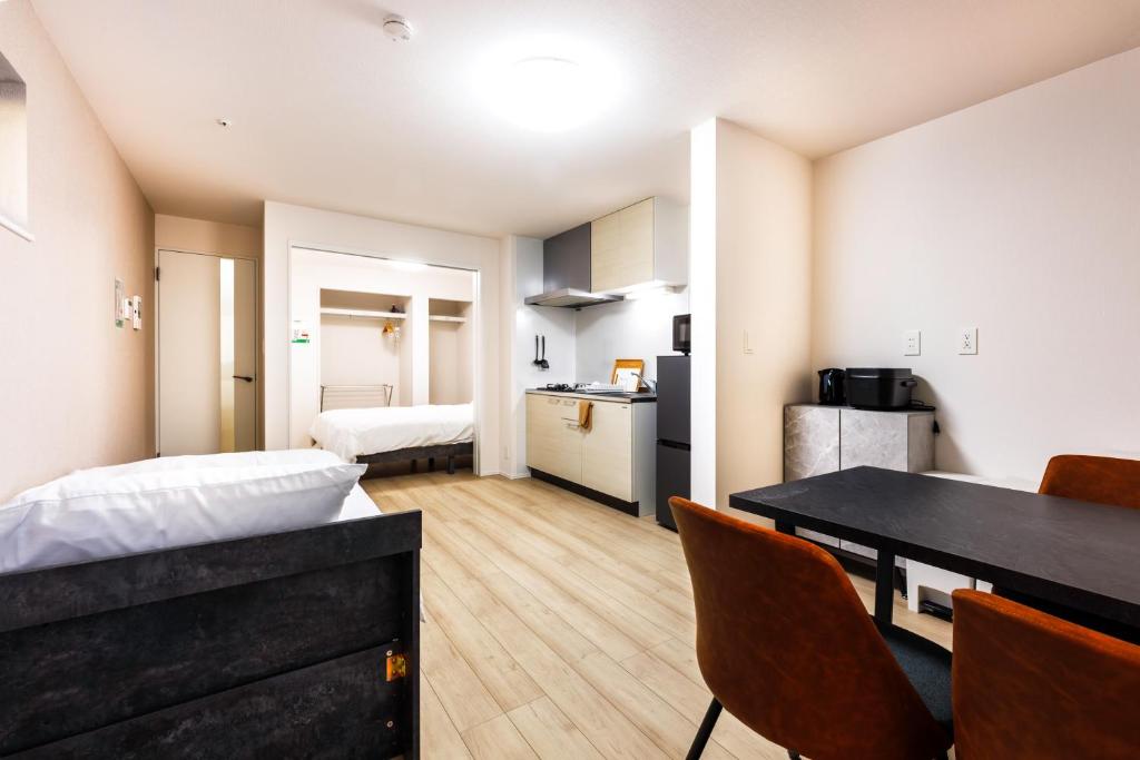 a small apartment with a dining table and a kitchen at Anecis笠取町2 in Nagoya