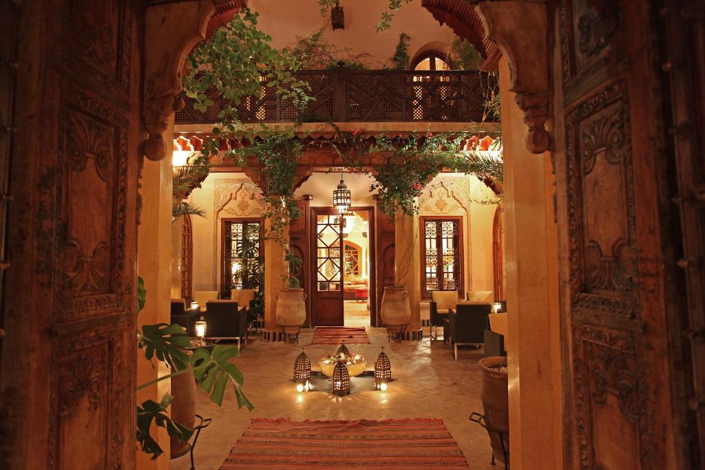 a hallway with a table and chairs in a building at La Maison Arabe Hotel, Spa & Cooking Workshops in Marrakesh