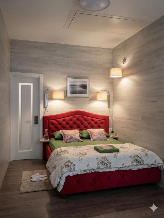 a bedroom with a red bed with a red headboard at Studio MD in Chişinău