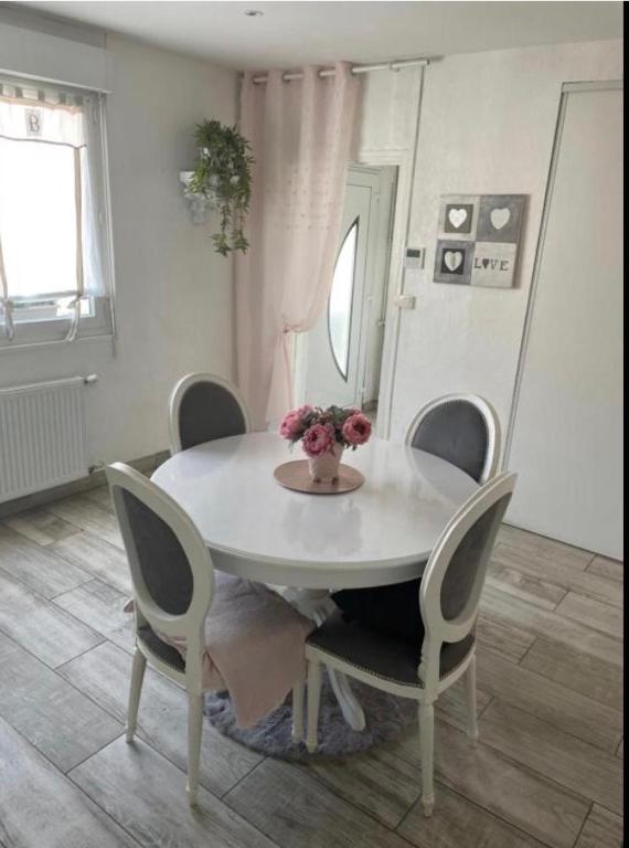 a white table with chairs and a vase of flowers on it at Chambre Maria in Le Pollet