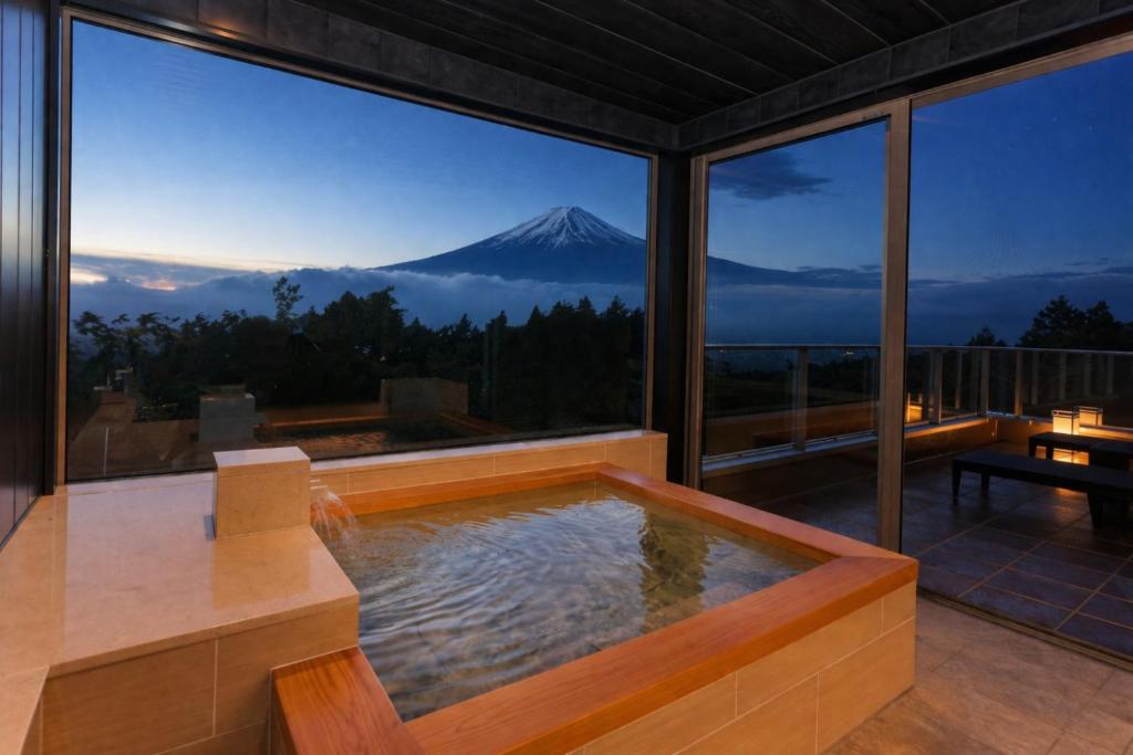 a jacuzzi in a house with a mountain in the background at Wellリゾート富士 in Gotemba