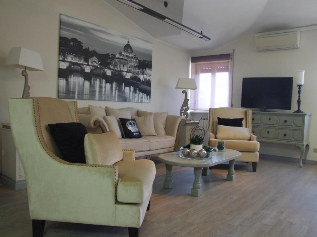 sala de estar con 2 sillas, sofá y mesa en Residenza i Ciclamini, en Roma