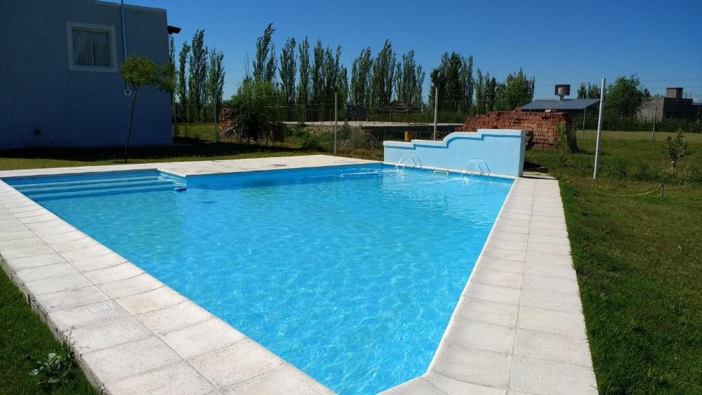 a large blue swimming pool in a yard at Complejo Las Cortaderas in San Rafael