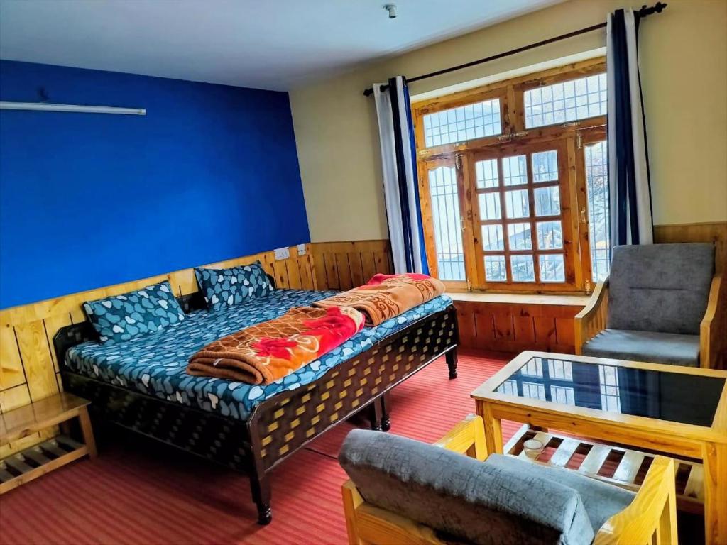 a bedroom with a bed and a couch and a chair at KC Homestay in Sissu
