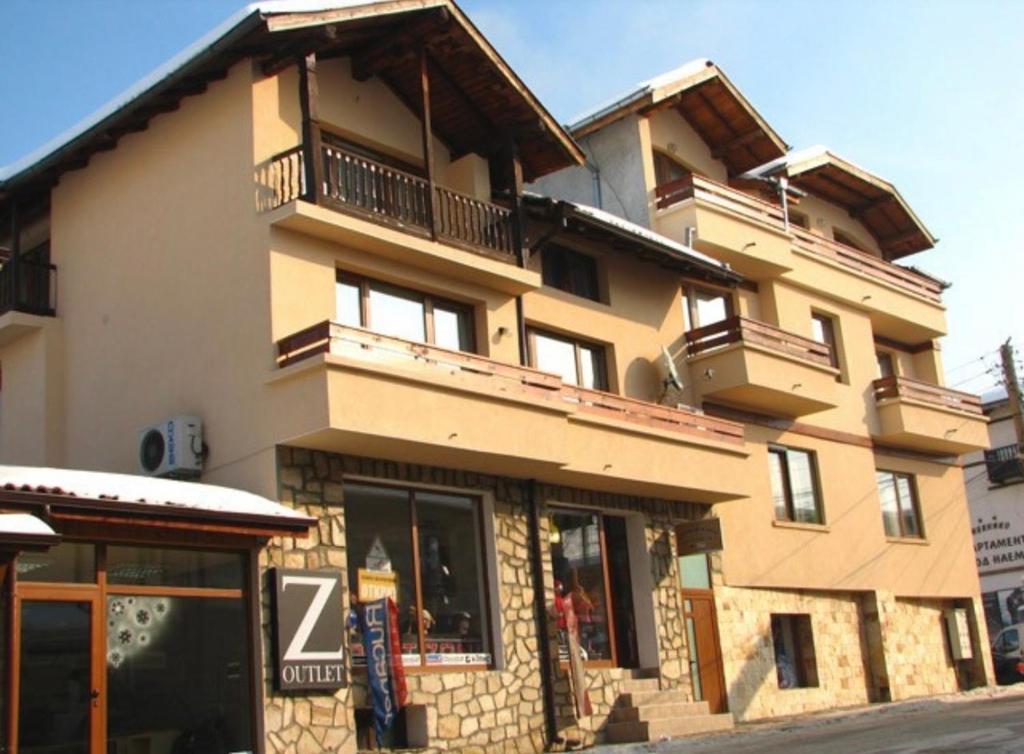 a large building with balconies on top of it at Hotel Boyanovi in Bansko
