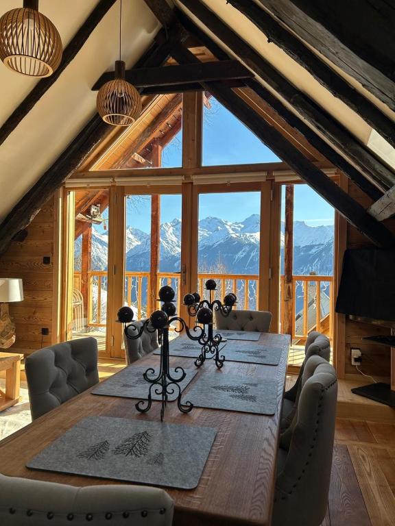 a dining room table with a view of mountains at Les Racines Chalet in Villard-Reculas