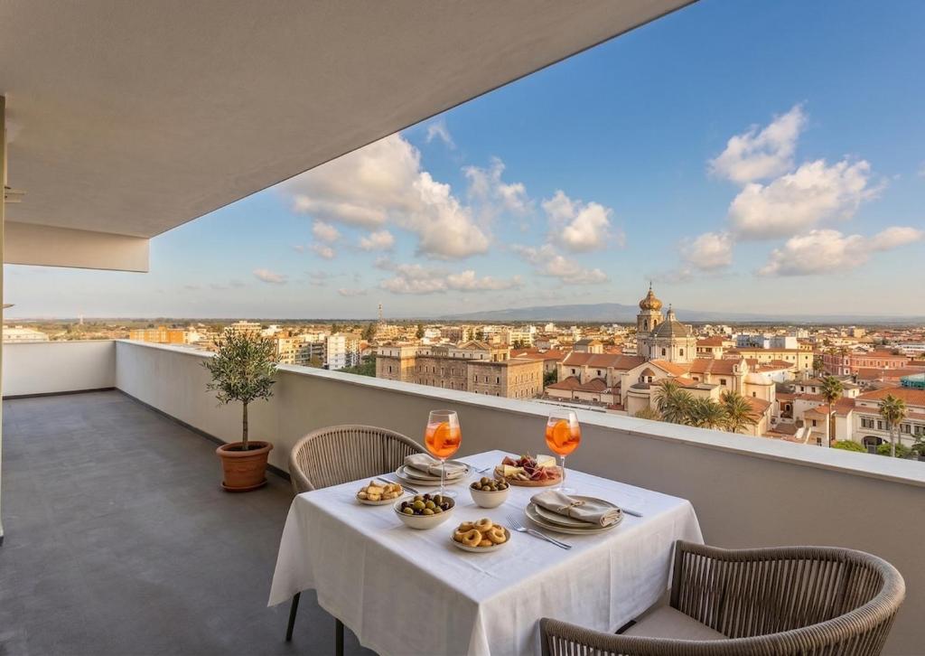 a table on a balcony with a view of a city at Penthouse Magic View - Large penthouse in the center in Oristano