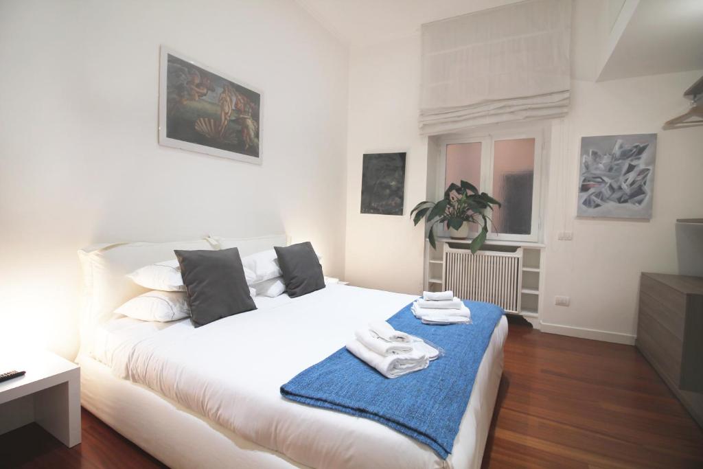 sypialnia z białym łóżkiem z niebieskim kocem w obiekcie Spanish Steps Art Apartment w Rzymie