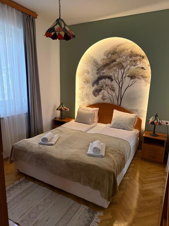 a bedroom with a large bed with two towels on it at Kozmáry Vendégház in Matrafured