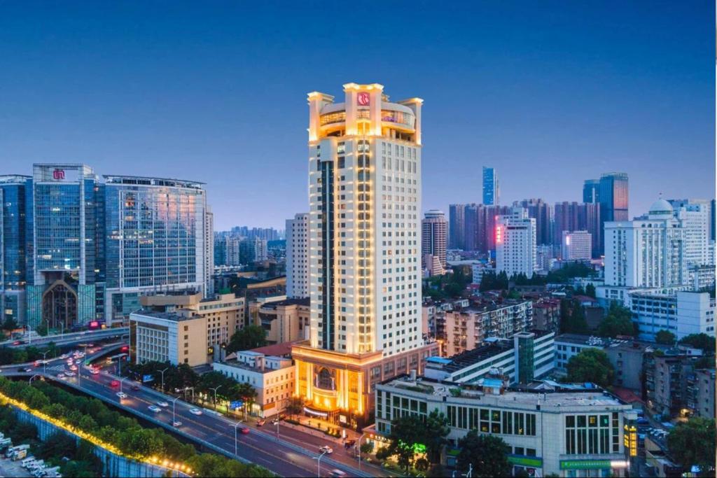 a city skyline with a tall white building and traffic at Ramada Plaza Tianlu Hotel in Wuhan