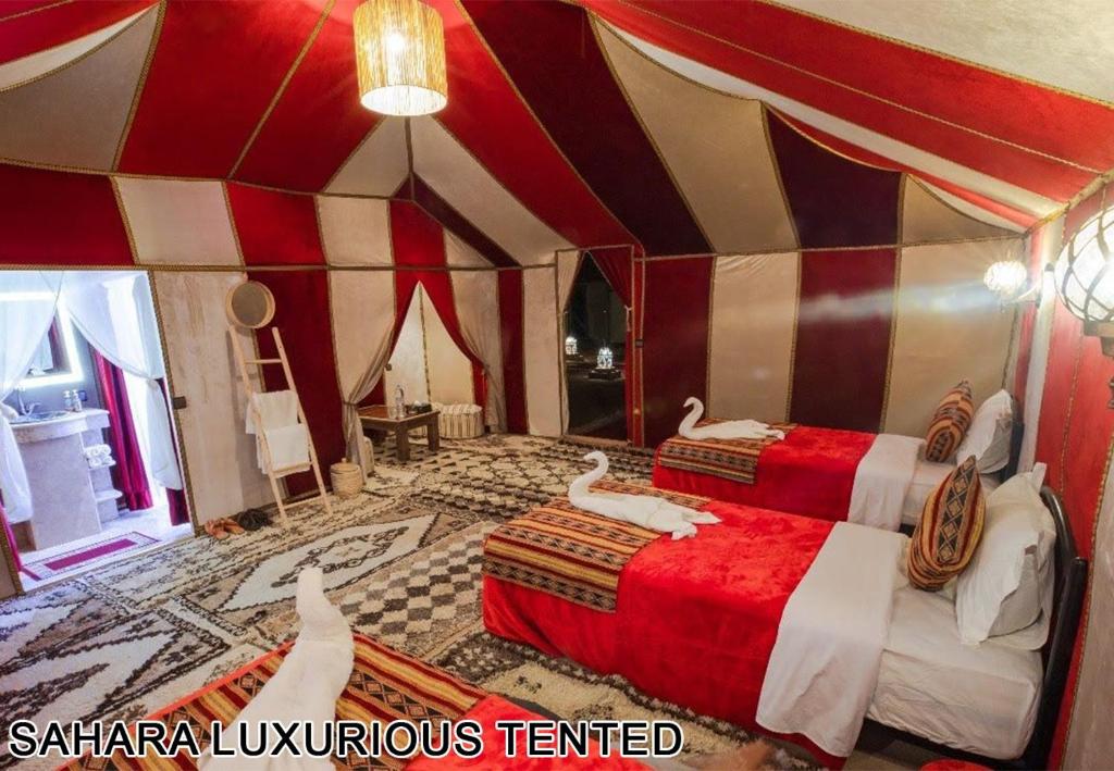 a room with two beds in a circus tent at Sahara Luxurious Tented in Merzouga