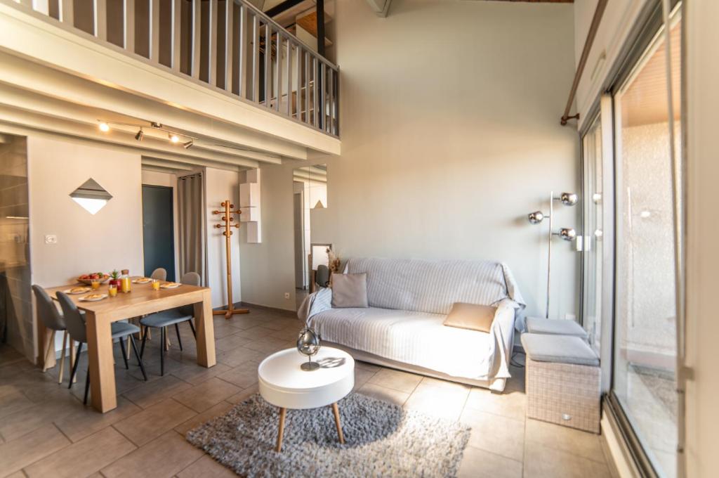a living room with a couch and a table at Le Donjon - Agréable T2 centre ville - parking gratuit 2 min - in Mont-de-Marsan