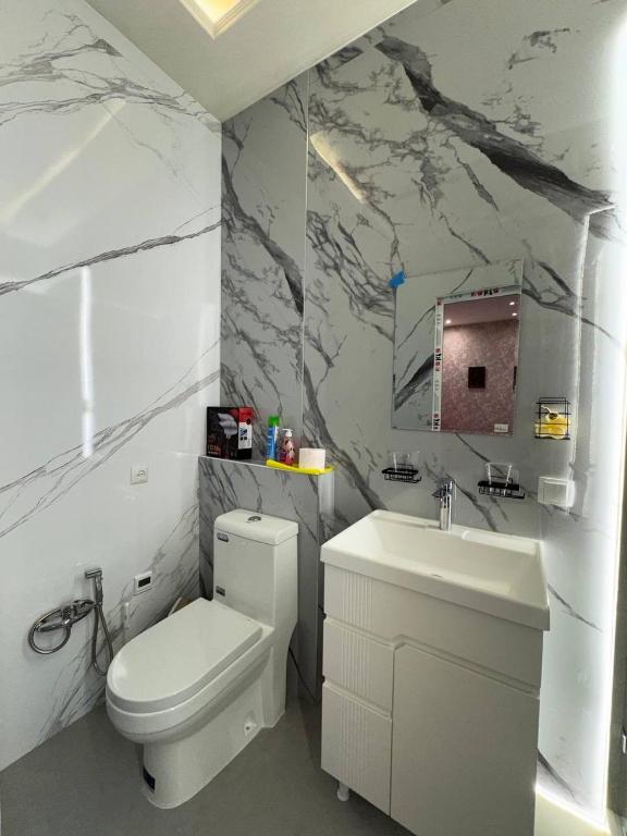 a bathroom with a white toilet and a sink at Водолей in Yalanghoch