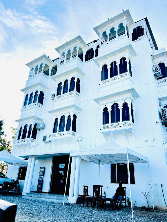 a white building with a table in front of it at Lotus hotel in Nāthdwāra