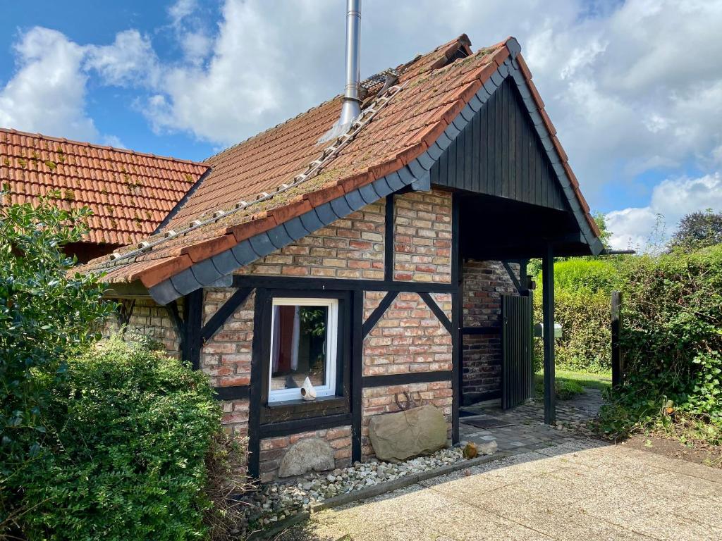 a small brick house with a red roof at Zum Schafstall in Hünxe