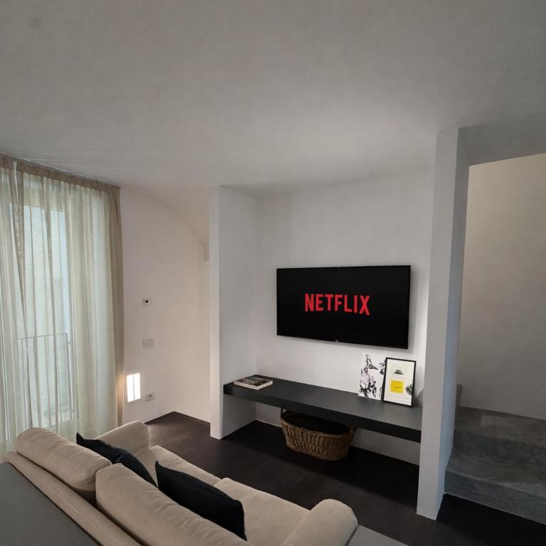a living room with a couch and a flat screen tv at R Platano House in Como
