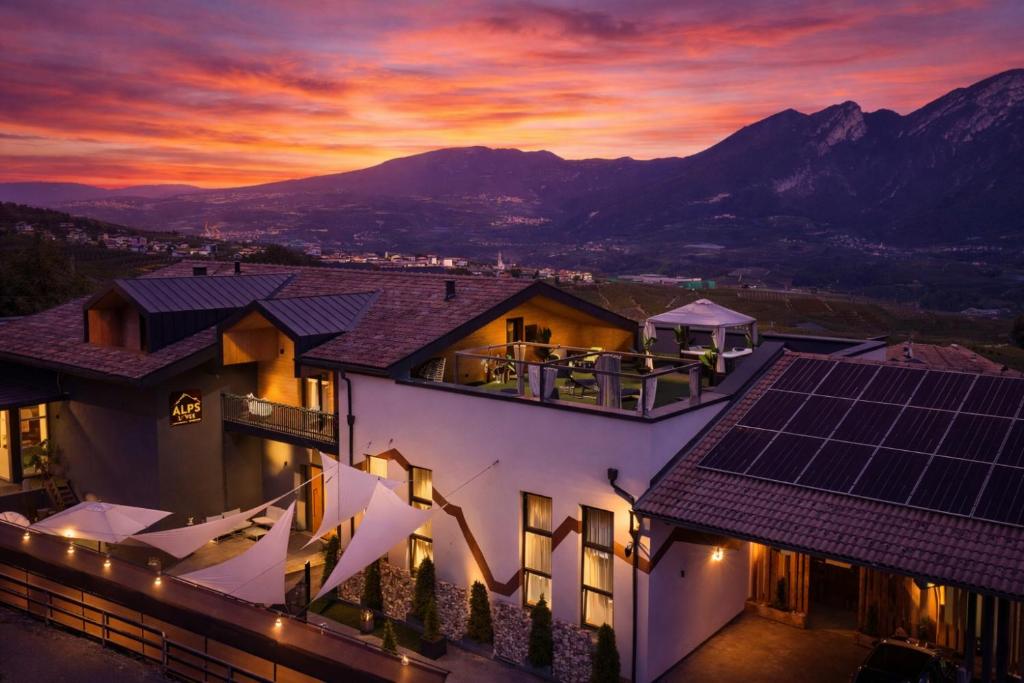 ein Haus mit Solarpaneelen auf dem Dach bei Sonnenuntergang in der Unterkunft ALPS LOVER in Campodenno