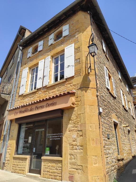 a brick building with a sign on it at Les Meublés des Pierres Dorées - Gite de charme pour groupe in Theizé