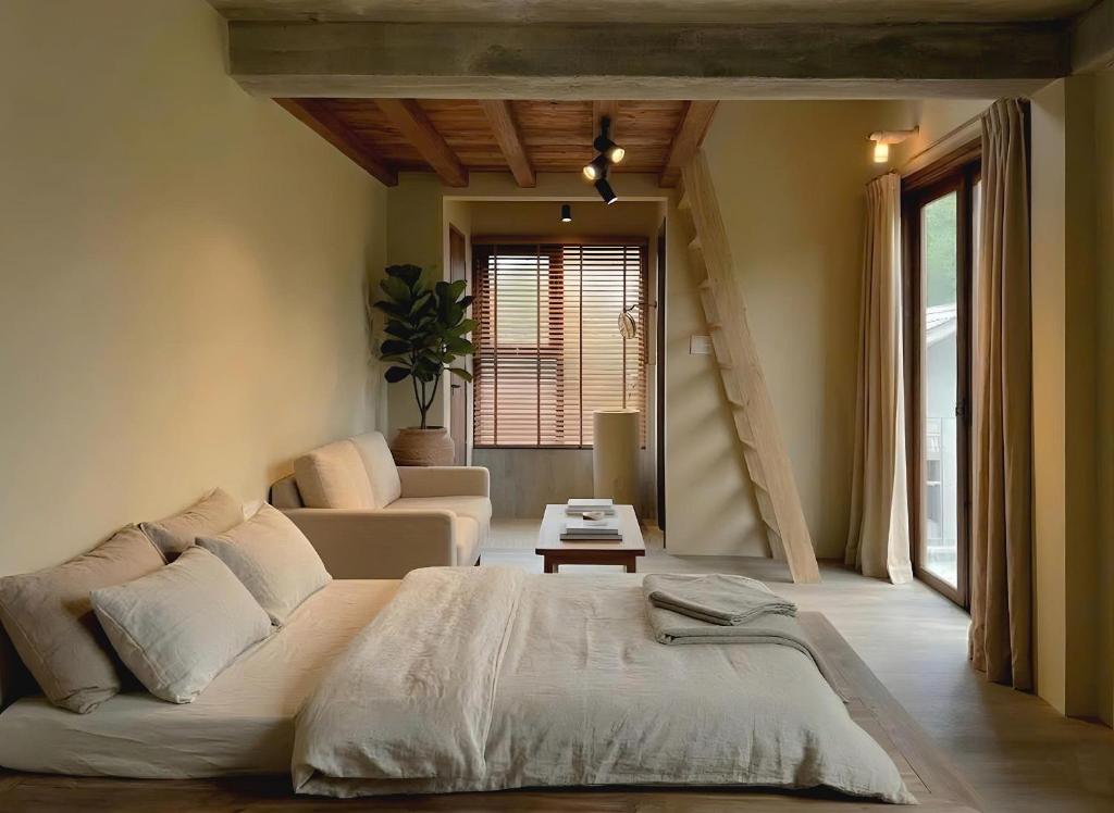 a bedroom with a large bed and a living room at Sum Homestay Hue - Gần cầu Nguyễn Hoàng in Hue