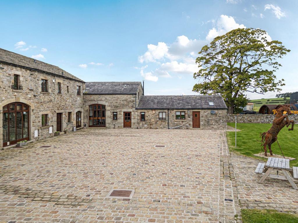 a stone building with a horse statue in front of it at Orcaber Farm Barn in Lancaster