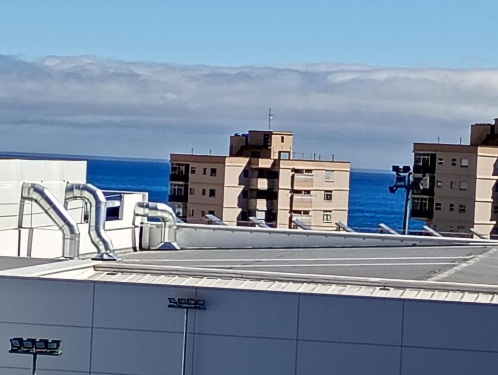 una vista de los tejados de los edificios y el océano en Little Italy, en Santa María de Gracia