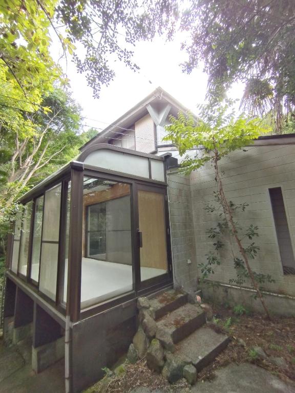 a small house with glass windows on the side of it at Mount Villa Atami in Kannami