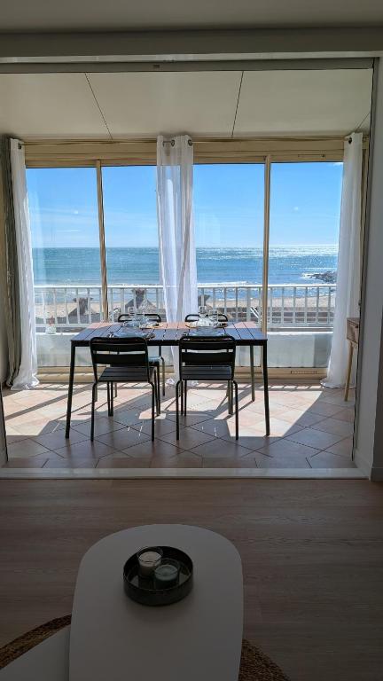 a dining room with a table and a view of the ocean at Horizon Bleu Duplex 2 chambres vue mer in Palavas-les-Flots