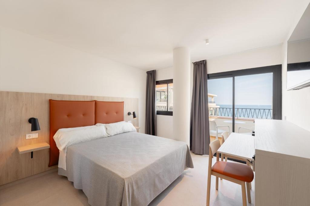 a hotel room with a bed and a balcony at Estudios RH Sol in Benidorm
