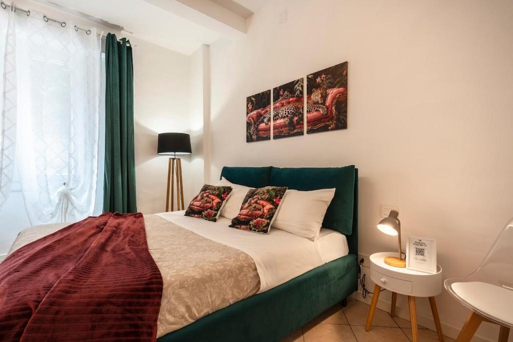 a bed with a green headboard in a bedroom at T'amo House in Macerata