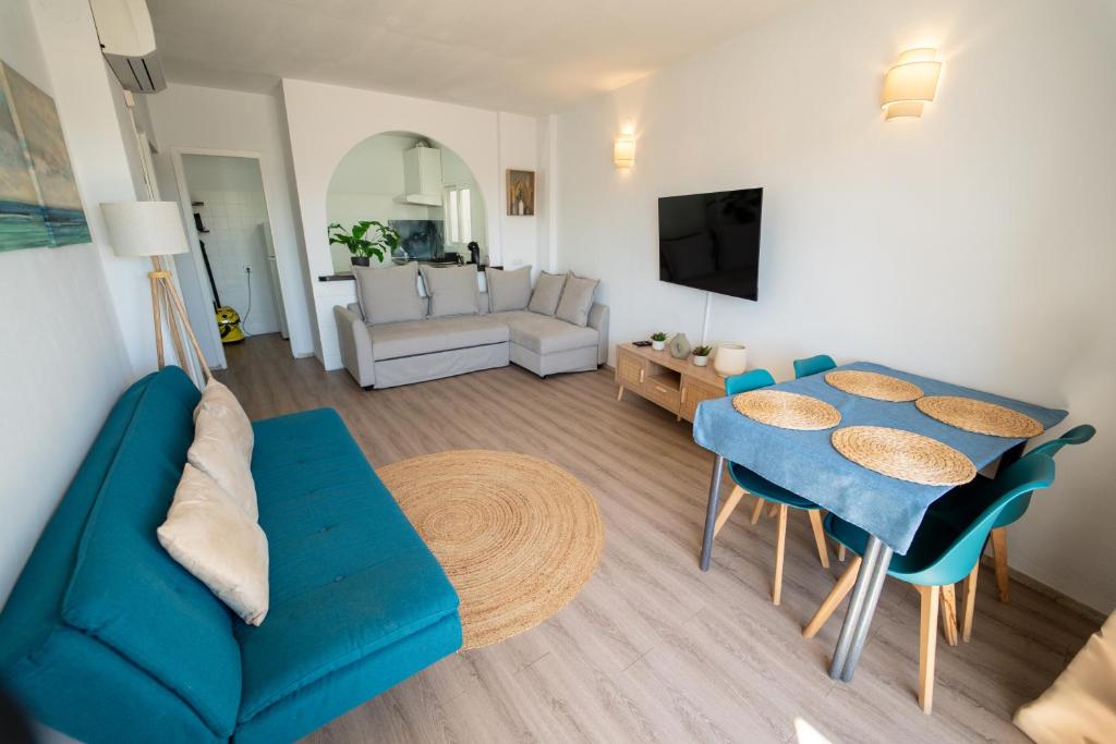 a living room with a blue couch and a table at Le Mirage Ibiza in San Antonio