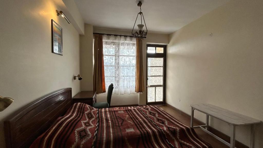 a room with a bed and a chair and a window at Lloyd's Vintage Home in Bhowāli