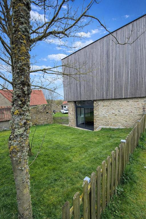 a house with a wooden fence next to a yard at Côte Saint-Pierre in Ambleteuse