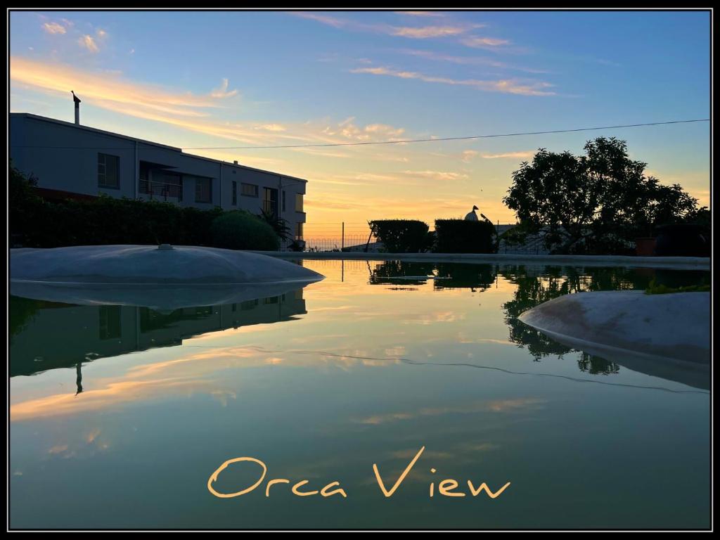 a view of a pool of water at sunset at Orca View Melkbosstrand in Melkbosstrand