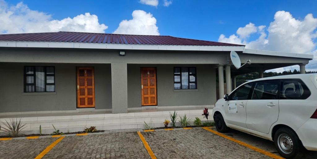 a white car parked in front of a house at Phelelani Lodge Jozini in Jozini