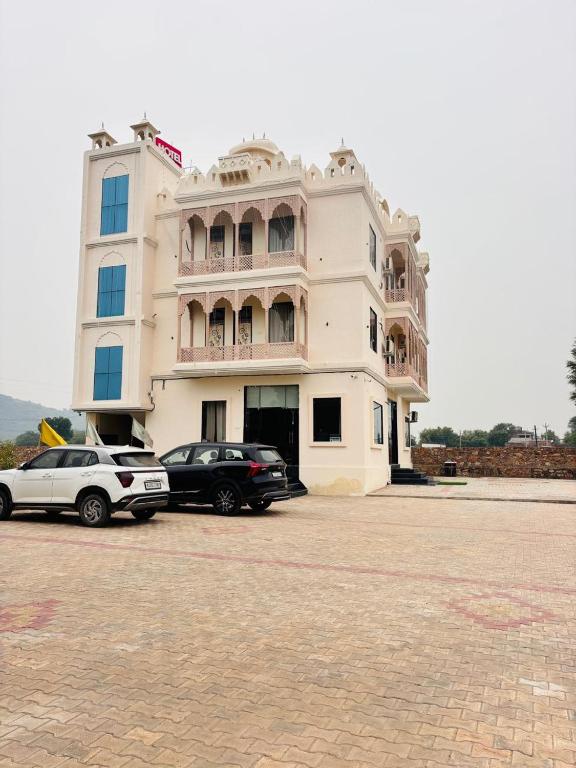 two cars parked in front of a white building at Eco Fort Hotel and Resort in Mahwah