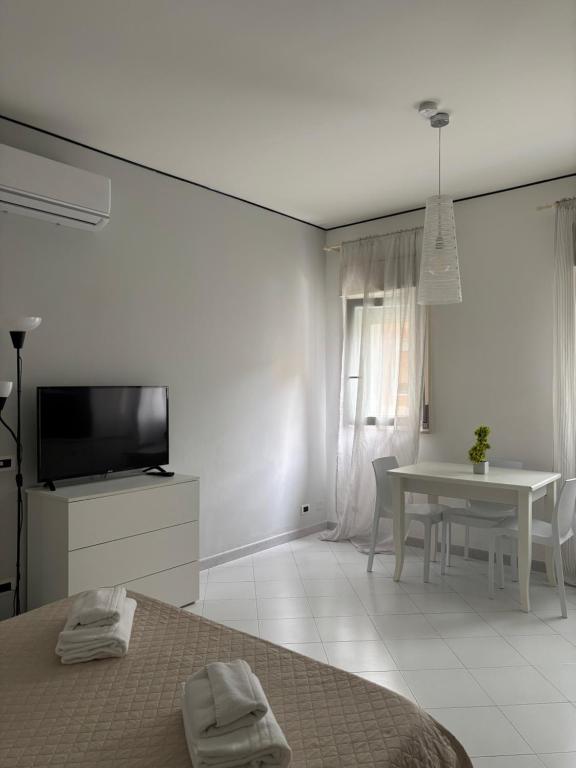 a bedroom with a bed and a table and a tv at Rael in Cefalù