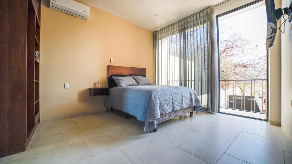 a bedroom with a bed and a large window at Casa las Castellanos in Tlalixtac de Cabrera