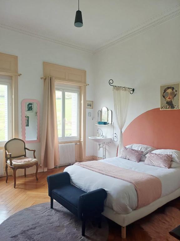 a bedroom with a large bed and a chair at La Petite Porte Verte in Bouilland