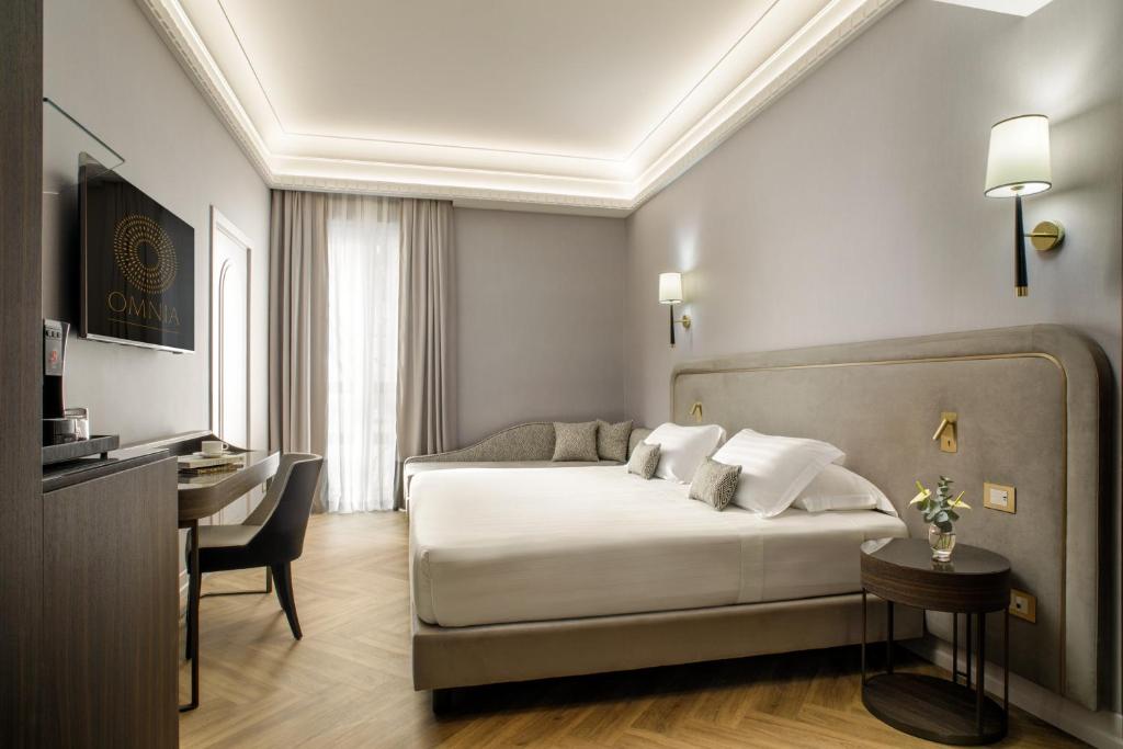 a hotel room with a bed and a desk at Aria Palace by OMNIA hotels in Rome
