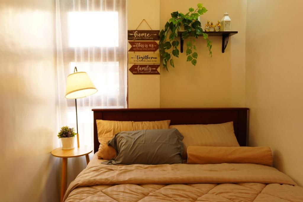 a bedroom with a bed with a lamp and a window at Balay Buenavista in Magdalena