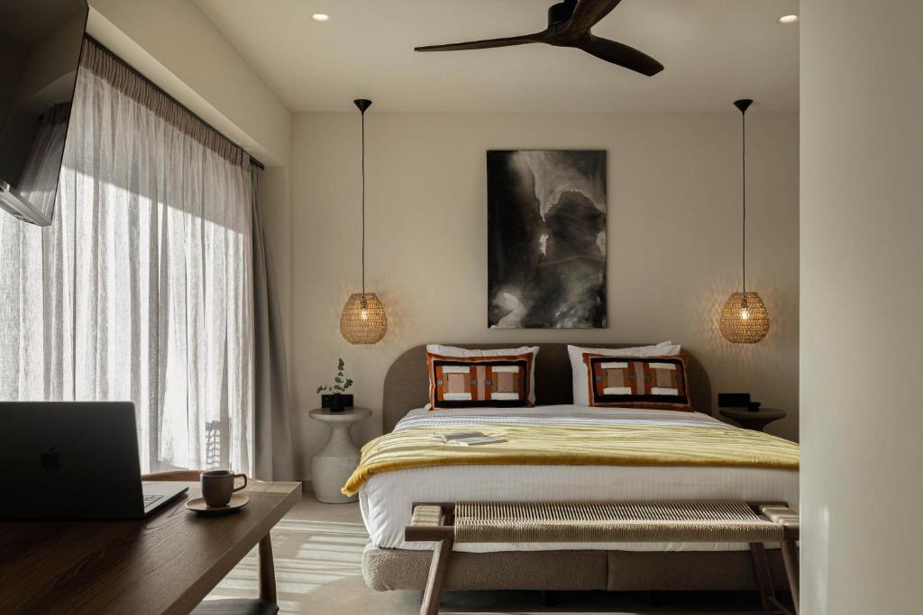 a bedroom with a bed and a laptop on a desk at MonCasa suites in Agios Nikolaos