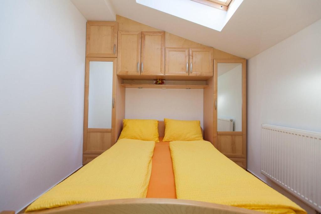 Habitación pequeña con 2 camas con sábanas amarillas. en Apartment Crikvenica 15 en Sopaljska