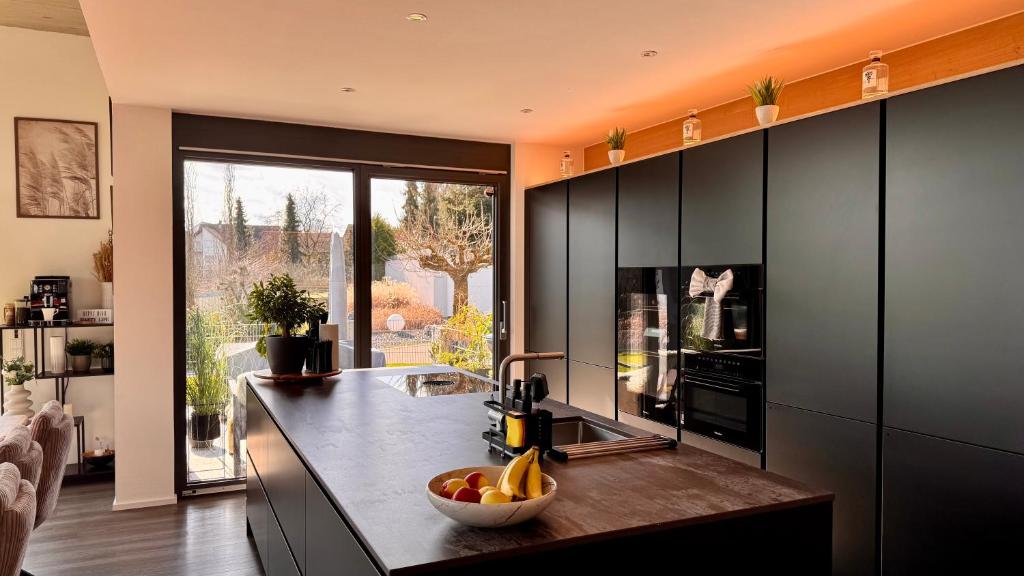 a kitchen with a counter with a bowl of fruit on it at Modern Luxury Apartment in Karsau