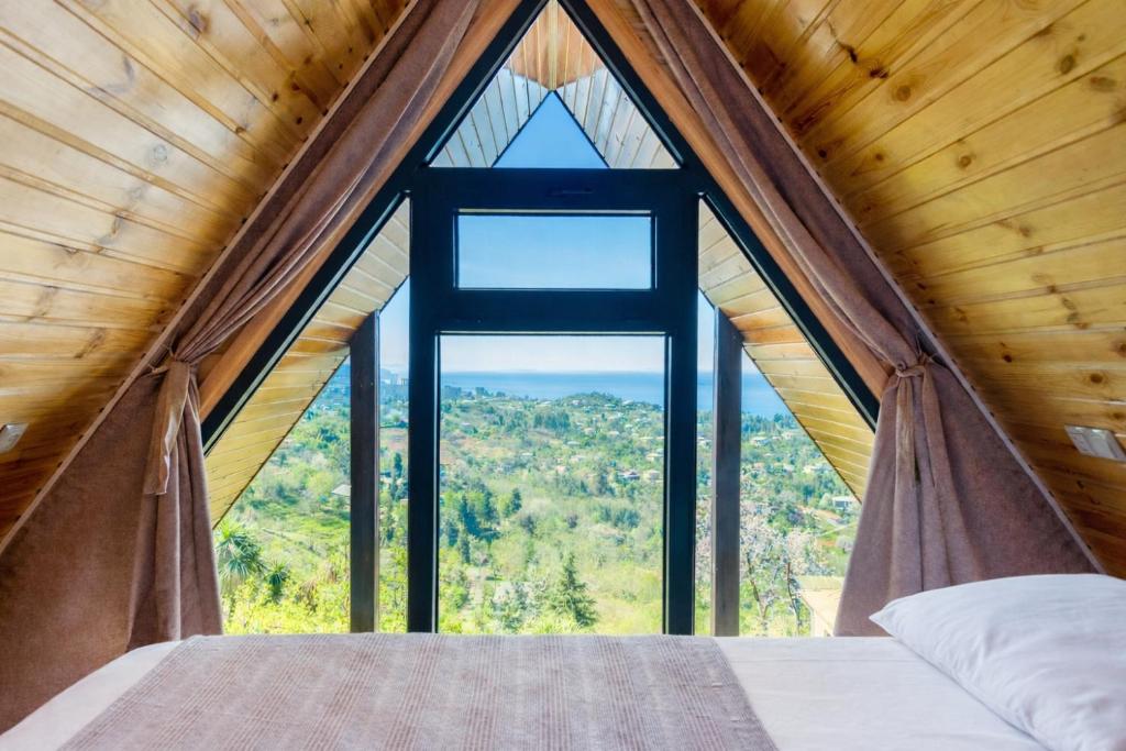 a bedroom in a tree house with a large window at Veranda Buknari in Buknari