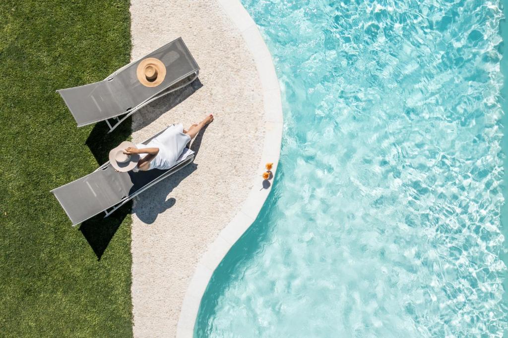 an overhead view of a man in a boat on a beach next to the water at Palatiana Agriturismo-Philoxenia Cottages Retreat in Galini