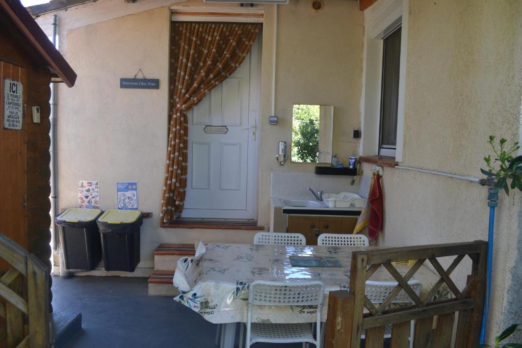 a room with a table and chairs and a kitchen at la PASSERONNE in Barbentane